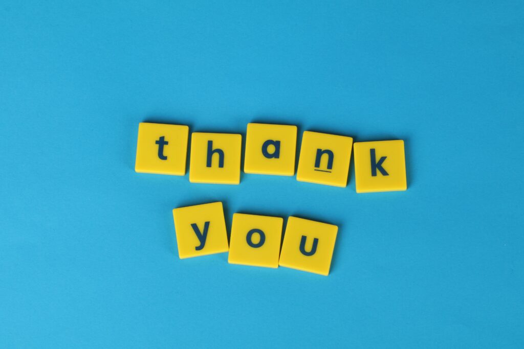 The words 'thank you' are pictured in dark lower case text within yellow scrabble-type blocks against a blue background
